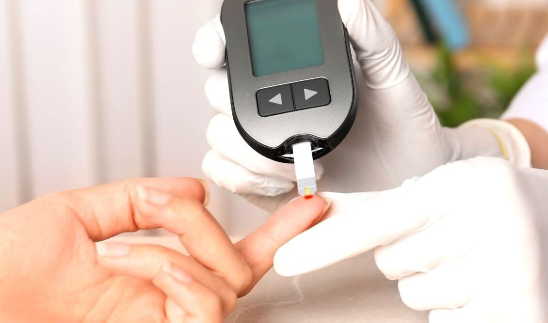 Μέτρηση ζαχάρου σε ασθενή από ιατρικό προσωπικό με γάντια.